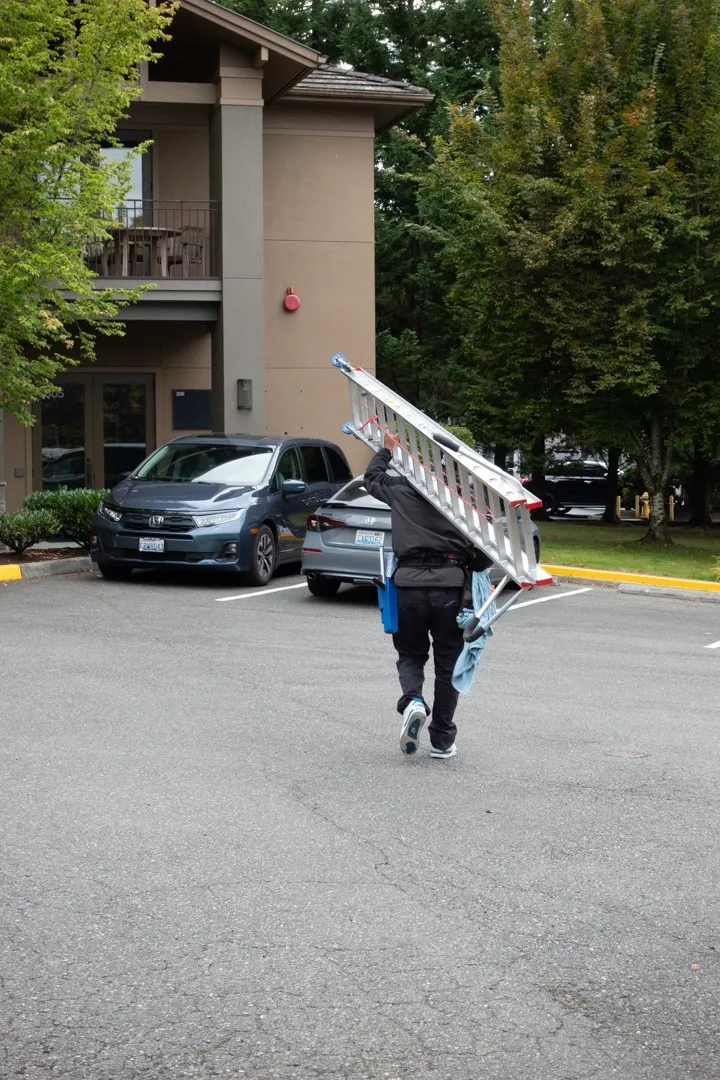 Ben carrying a ladder across a Seattle parking lot