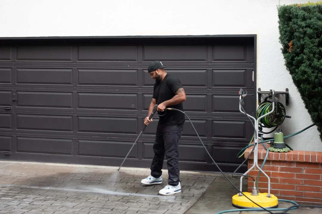 Ben pressure washing a paver driveway