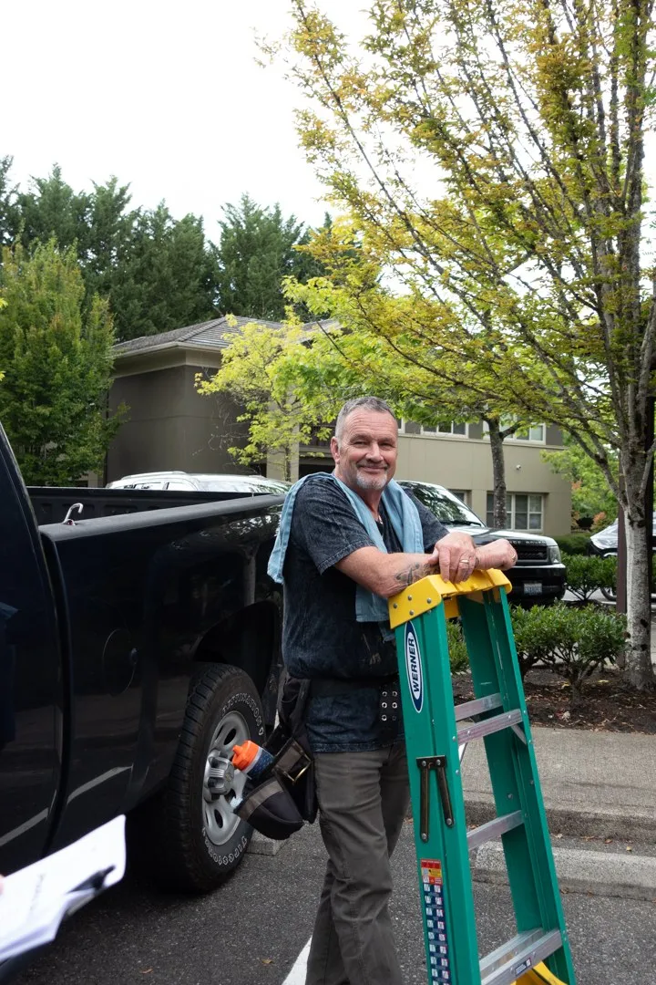 John with his ladder beside the truck in a Seattle lot